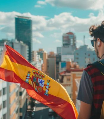 un-joven-con-una-bandera-espanola-mirando-el-paisaje-de-la-ciudad-en-un-dia-soleado
